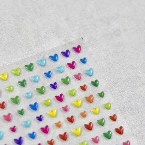 Close-up of 3D heart nail art stickers with vibrant colors and glossy resin finish