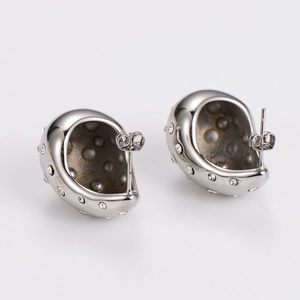 Macro shot of silver teardrop earrings with embedded crystals and stainless steel studs