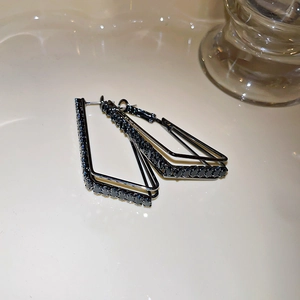 Macro shot of black geometric tassel earrings with micro-pave cubic zirconia crystals