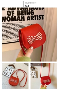 Detail of red mini crossbody bag featuring a white pearl bow ornament on the flap