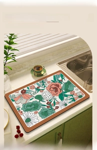 Absorbent floral dish drying mat with faux leather edges on a kitchen countertop