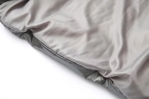 Detailed macro view of the grey metallic silk-gloss fabric texture of the padded jacket