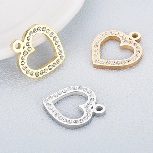 Close-up of heart-shaped stainless steel charms in gold, silver and rose gold with zircon