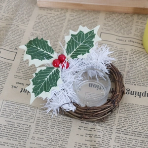 Détail de la couronne de bougie de Noël avec baies rouges, feuilles et verre