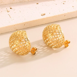 Close-up of gold irregular C-shape woven earrings on textured stone stand