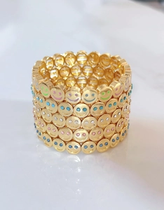 Detail of gold elastic bracelet featuring multi-row colorful crystal smiley faces