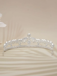 Detailed view of vintage silver bridal tiara with intricate floral leaf and crystal patterns