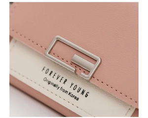 Macro shot of faux leather wallet featuring a pink color block design and metal buckle