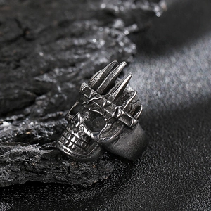 Detailed view of punk rock skull ring with claw design on vintage dark stone surface
