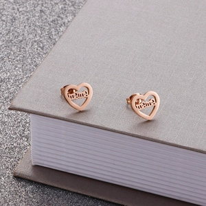 Macro detail of rose gold hollow heart-shaped studs featuring the mama text design