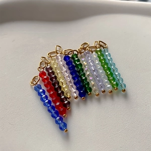 Close-up van gekleurde kristallen kralenhangers met gouden sluitingen voor DIY-sieraden.