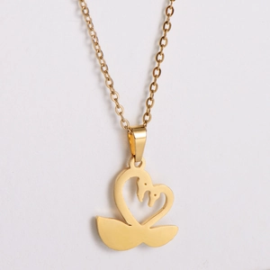 Golden double swan heart pendant necklace with fine link chain on white background