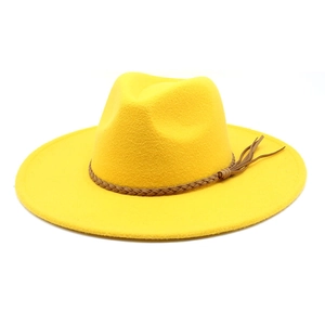 Detailed close-up of yellow wool fedora hat with brown braided leather band and tassels