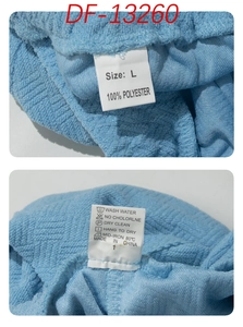 Detail view of clothing label showing 100% polyester fabric and L size on blue textured cloth