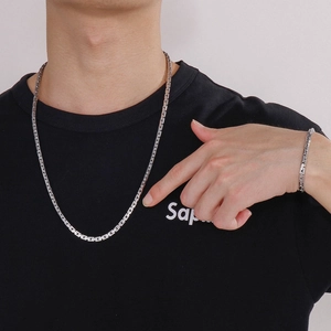 Modern unisex stainless steel silver chain necklace and bracelet set shown on model