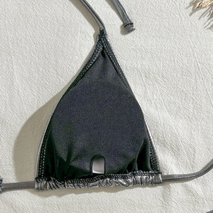 Macro detail of silver metallic bikini cup with black lining and removable pad pocket