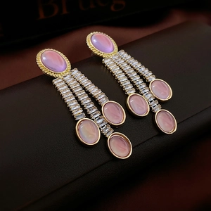 Dettaglio di orecchini vintage dorati con pietre ovali rosa e nappe di zirconi brillanti