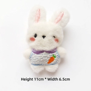 Detail view of 11cm white plush bunny charm with blue knit vest and carrot embroidery
