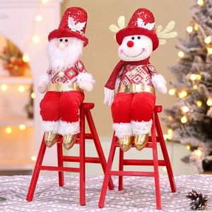 Close-up of Santa and Reindeer plush dolls on red ladder with festive bokeh background