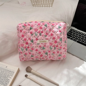 Close-up of pink quilted tulip floral makeup bag with Scaakka label on a desk
