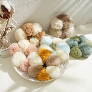 Set di cinque elastici per capelli in peluche colorati in un piatto bianco decorato