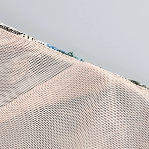 Close-up of pink embroidered fabric with fine mesh texture and green stitching detail