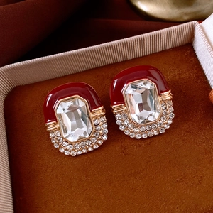 Macro view of vintage palace style earrings with red enamel and rectangular crystal