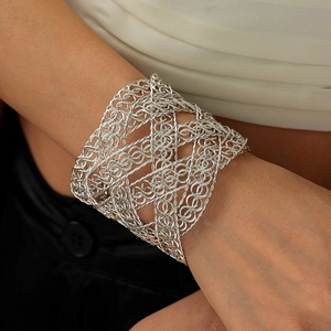 Close-up of wide hollow woven silver cuff bracelet with intricate wire mesh texture