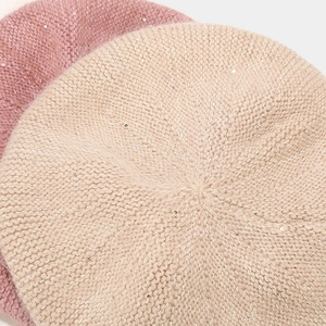 Détail du tricot et des paillettes sur les bérets citrouille en beige et rose pastel