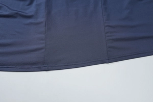 Detailed close-up of double-needle stitching on the hem of a navy blue knit dress