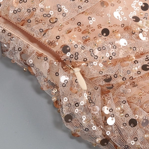 Close-up of sequin fabric with faux pearl beads and hidden zipper detail on formal dress