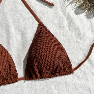 Detail of rust brown seersucker bikini top with textured fabric and halter neck ties