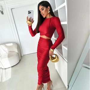 Dettaglio della texture arricciata rossa e del tessuto setoso del set top e gonna