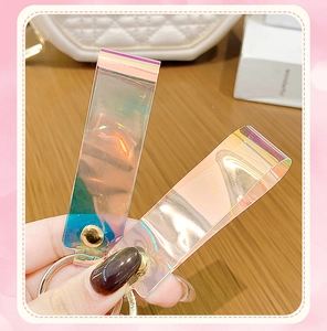 Iridescent PVC lanyard keychains with golden metal rings shown on a wooden desk