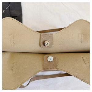 Dettaglio della chiusura magnetica su borsa tote in ecopelle kaki con trama a grana
