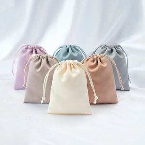 Detail of drawstring satin jewelry pouches in six elegant Morandi colors on white silk