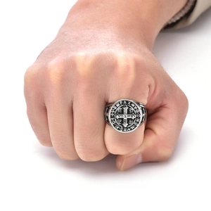 Macro shot of vintage St. Benedict medal ring in silver steel on a male model hand