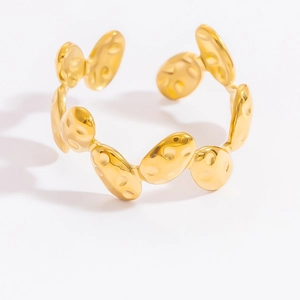Detailed view of the gold-plated textured oval link cuff bracelet on white background