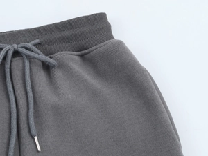 Detailed macro view of dark grey ribbed waist with adjustable metal tipped drawstring