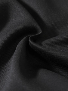 Macro shot of black woven fabric showing fine plain weave texture and soft pleats