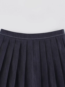 Dettaglio ravvicinato della vita e del design a pieghe su una gonna di jeans blu scuro