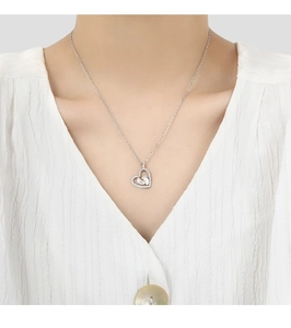 Detailed close-up of a heart pendant necklace with baby footprints on a model