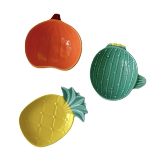 Cute ceramic dipping sauce dishes in pumpkin cactus and pineapple shapes on white background