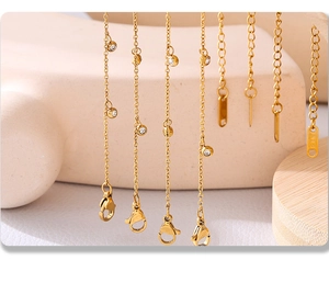 Detail of 18K gold bead anklet chains with lobster clasps and zircon accents