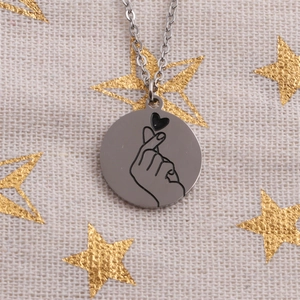 Collier rond en acier inoxydable poli avec pendentif geste de cœur sur tissu