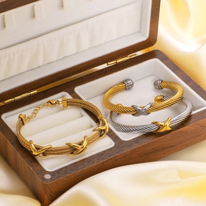 Bracelets torsadés vintage en or et argent présentés sur satin dans une boîte en bois
