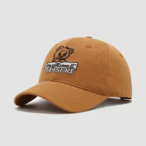 Close-up of caramel cotton baseball cap featuring detailed bear embroidery and text
