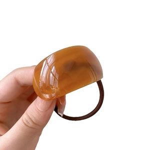 Chic amber resin curved hair tie with brown elastic band for minimalist ponytail styling