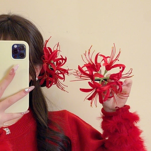 Detailed view of red Lycoris hair clips made of silk fabric for traditional styling