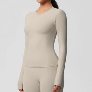 Gros plan sur la texture du tissu brossé beige et les coutures du haut de yoga